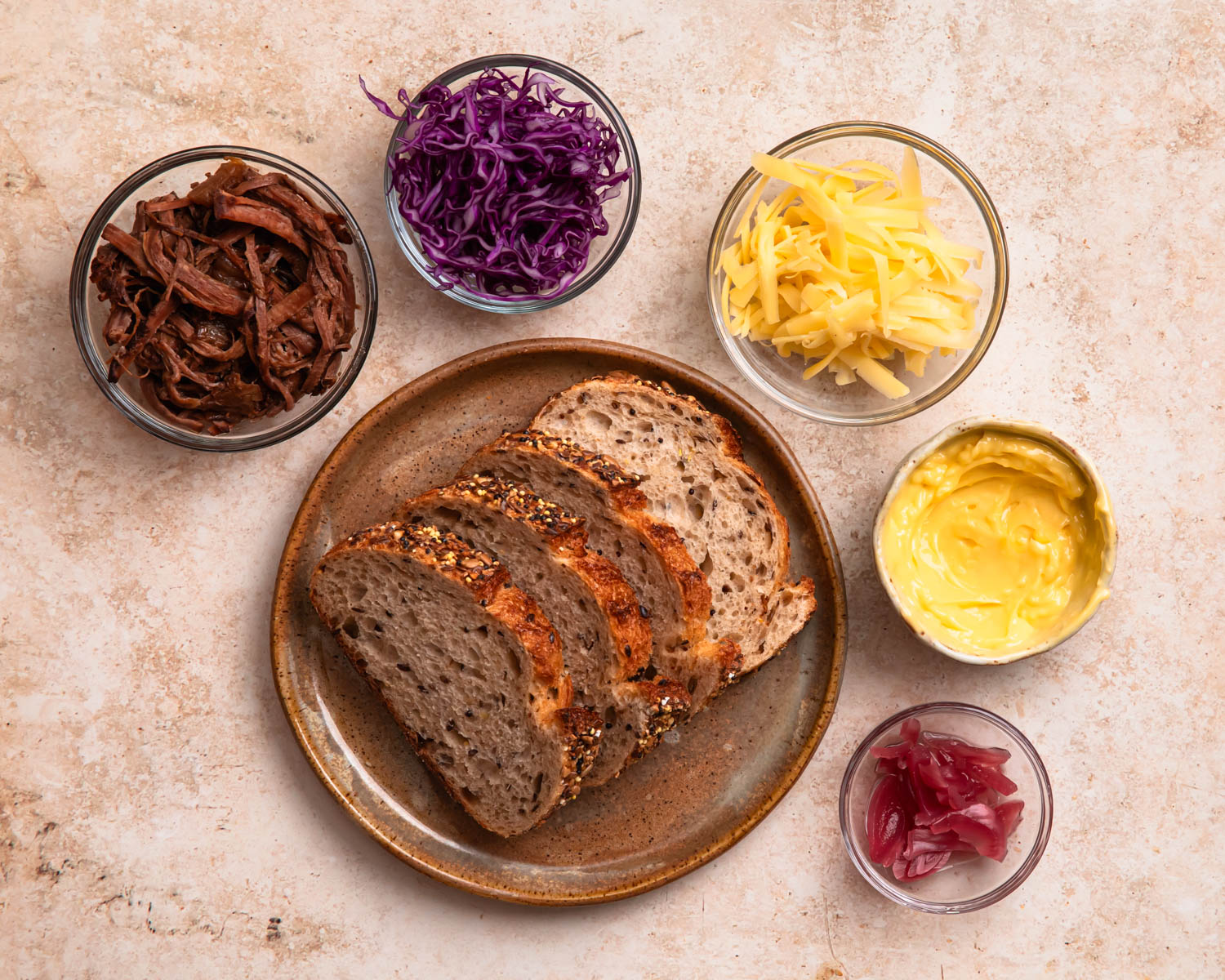 Ingredients for grilled cheese brisket laid out in individual bowls. 