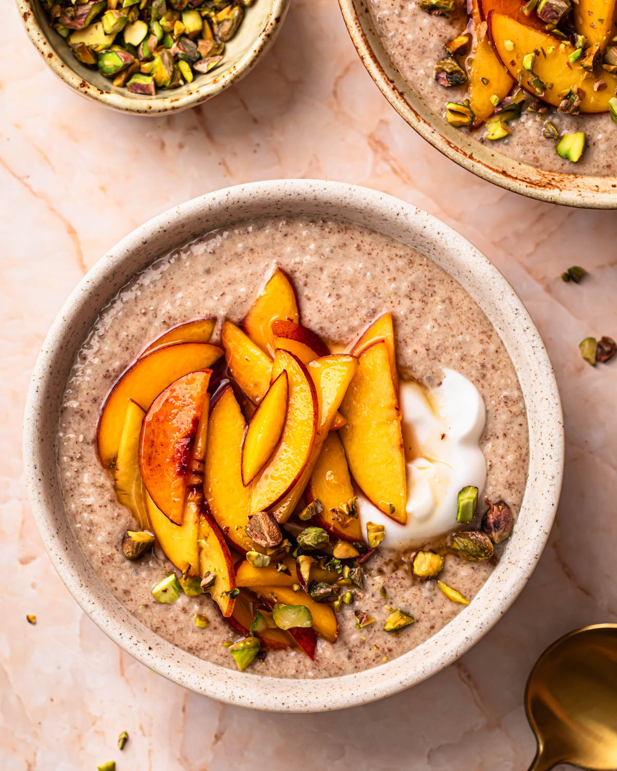 Chia and flaxseed pudding topped with peaches, yoghurt and crushed pistachios.