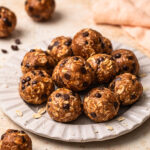 Choc chip oat energy balls arranged on a plate.