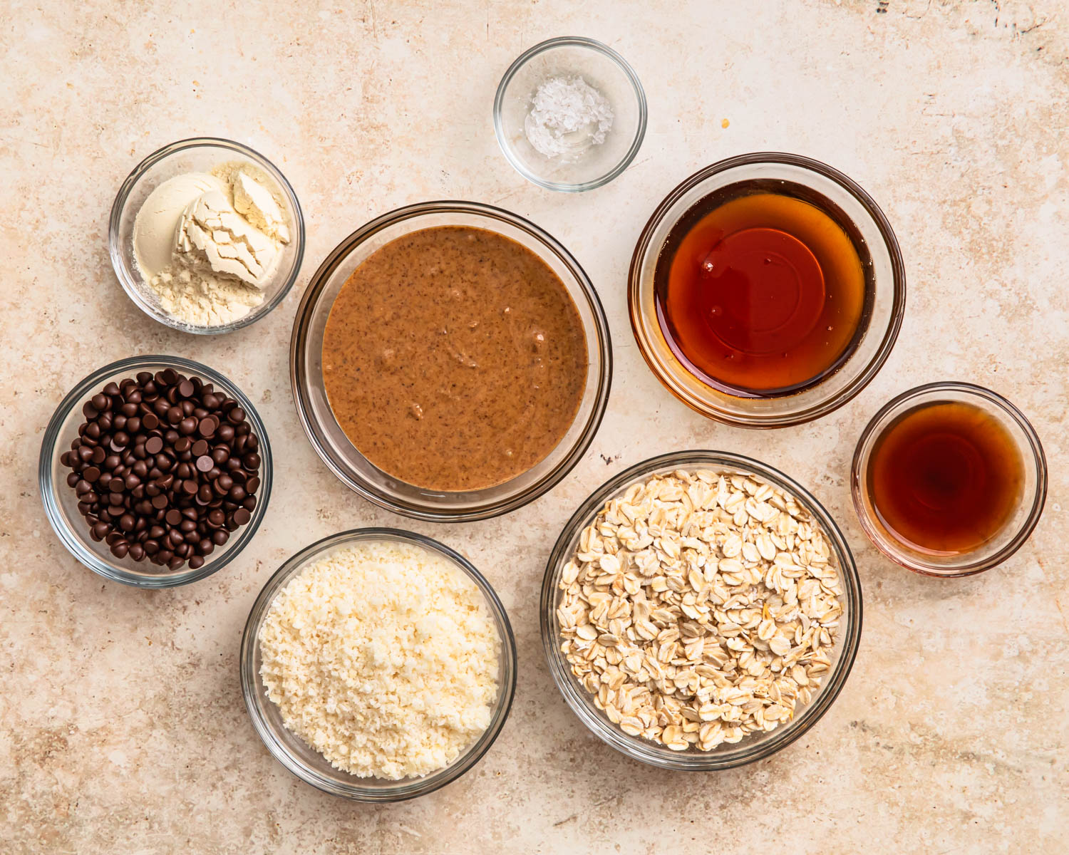 Ingredients for choc chip oat energy balls laid out in individual bowls. 