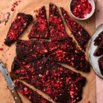 Dark chocolate date bark topped with freeze dried strawberries and chopped into pieces.