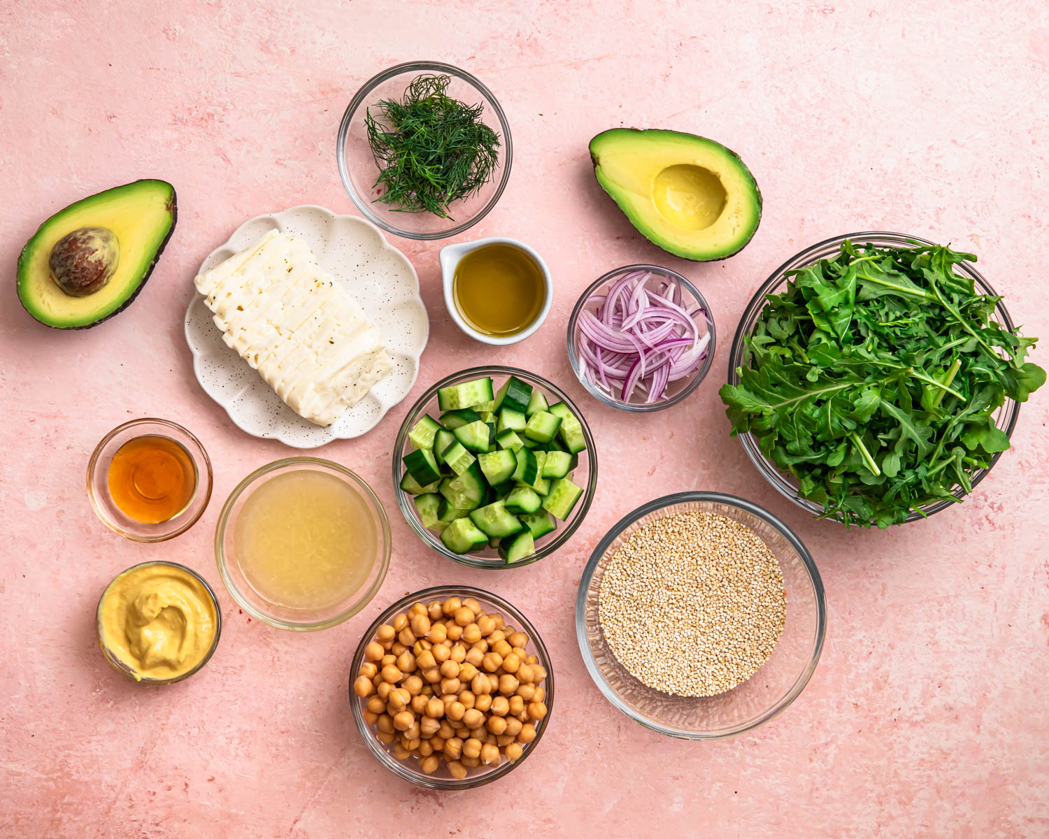 Ingredients for halloumi avocado salad laid out in individual bowls.