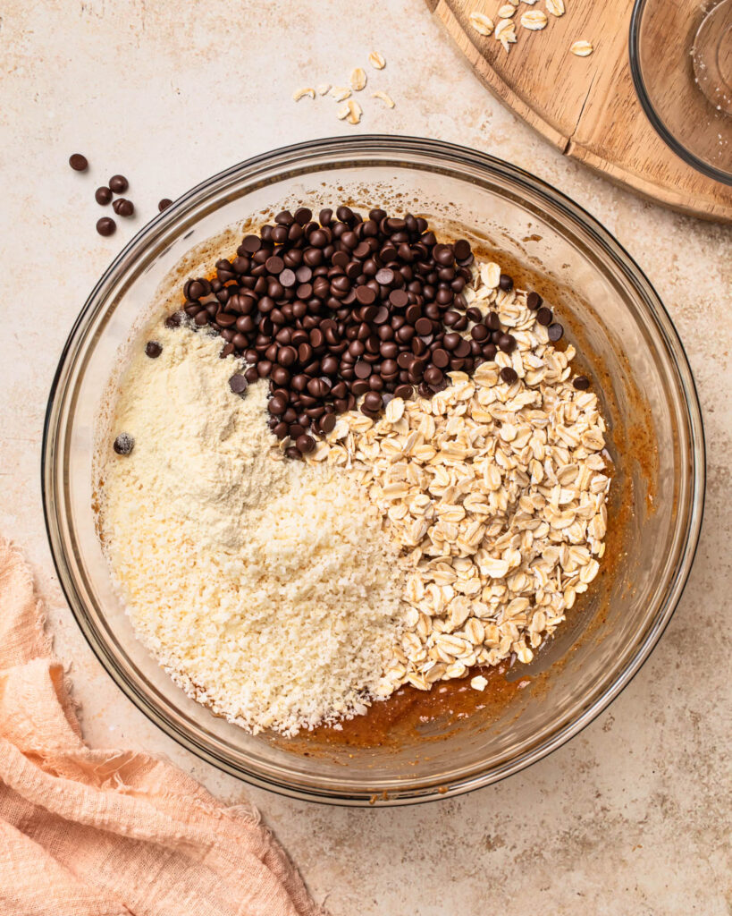Dry ingredients added to wet ingredients to make oat energy ball mixture. 