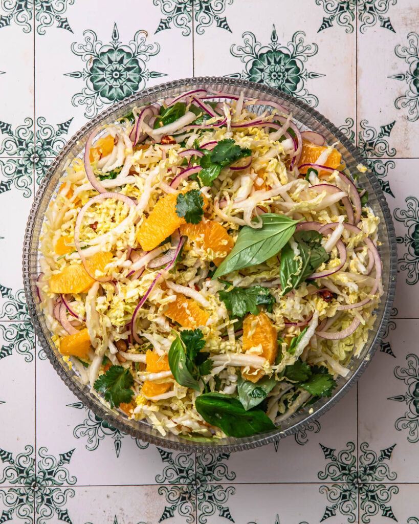 Citrus slaw tossed together in a glass bowl. 