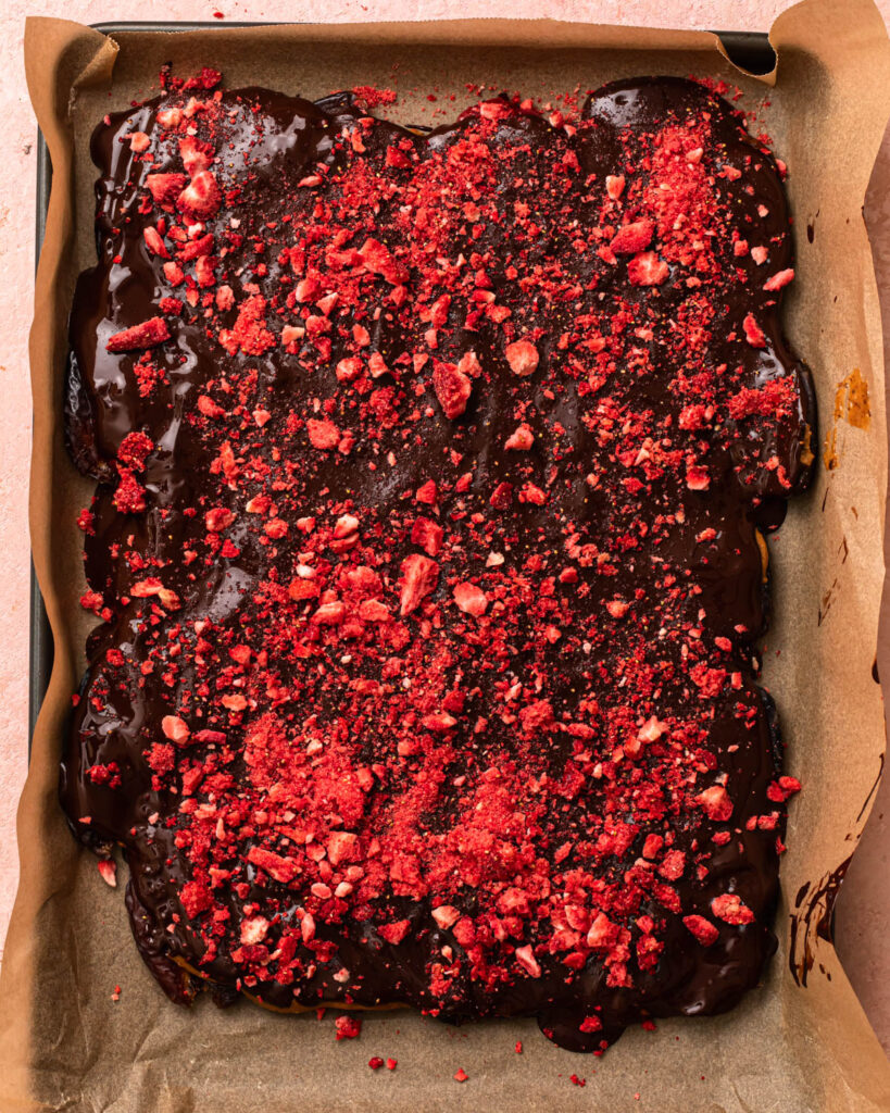 Crushed freeze dried strawberries sprinkled over the layer of dark chocolate to make date bark.