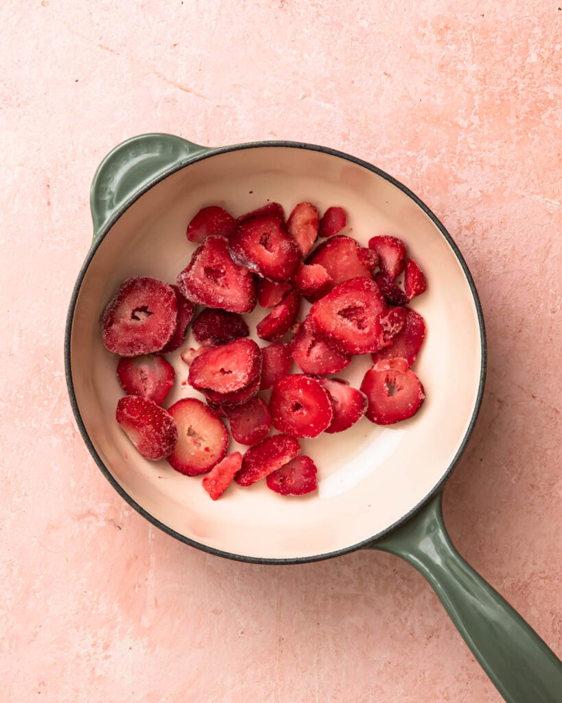 Frozen strawberries added to a pan.