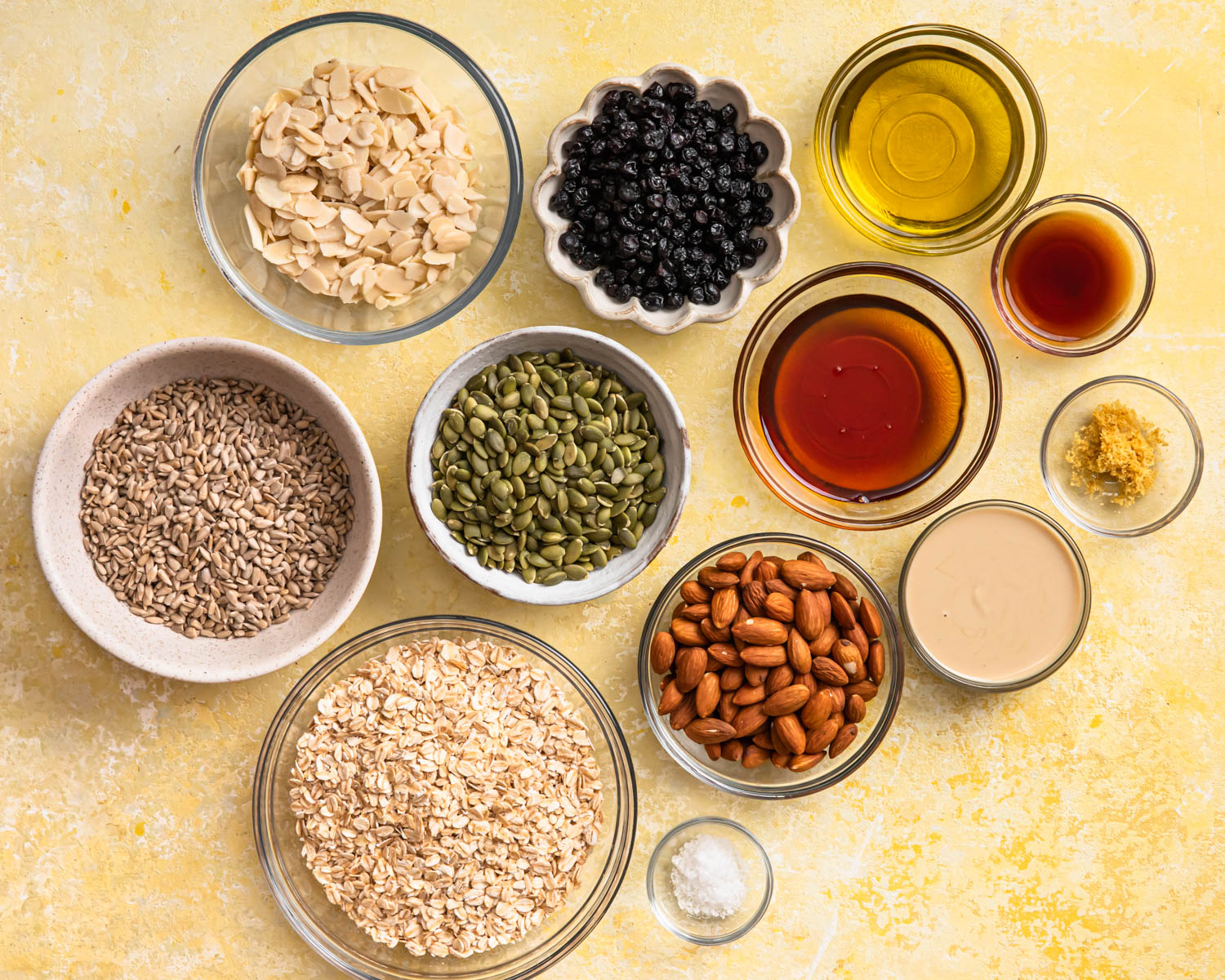 Ingredients for lemon blueberry granola laid out in individual bowls.