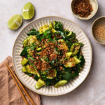 Smashed Sesame Cucumber Salad on a serving plate, topped with fried onions.