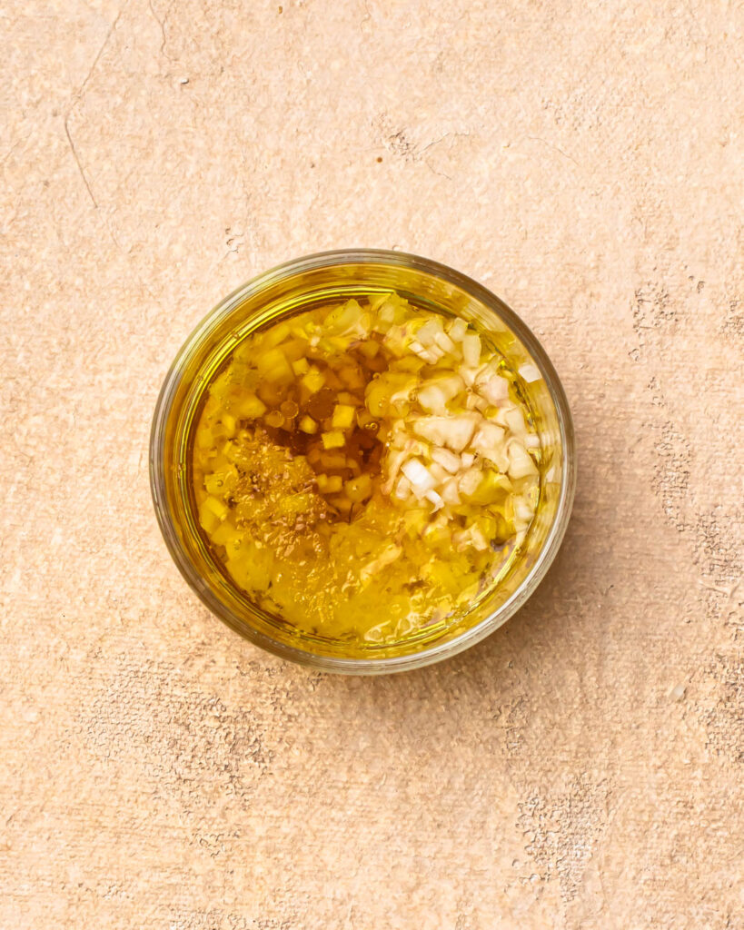 Ingredients for a vinaigrette added to a jar. 