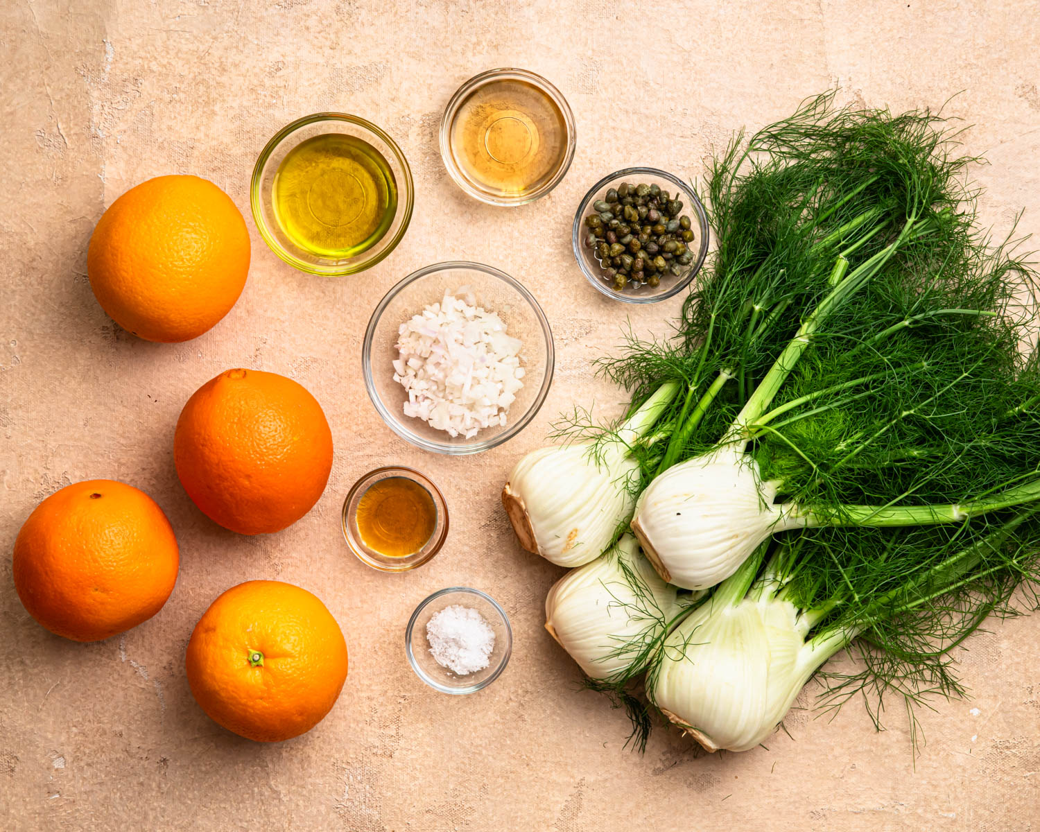 Ingredients for orange and fennel salad laid out in individual bowls. 