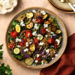 Roasted zucchini quinoa salad in a bowl, topped with goats cheese.