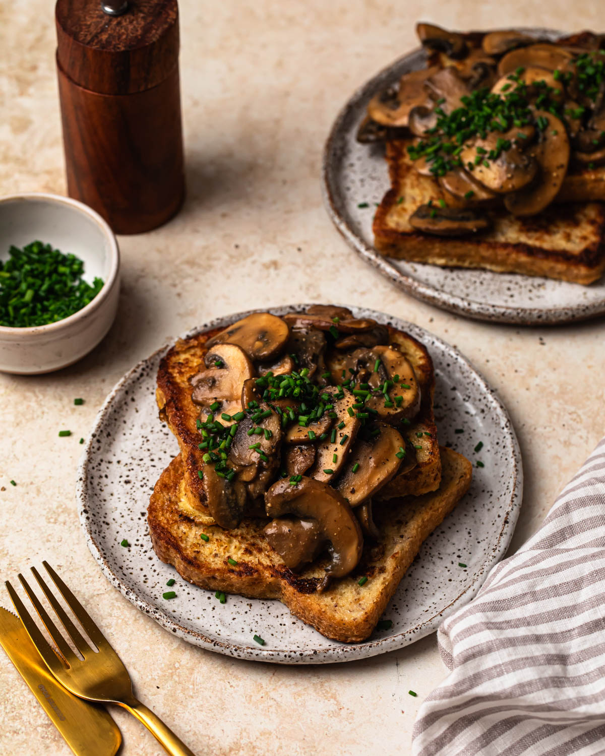Savoury French Toast on a plate topped with miso butter mushrooms and chopped chives.