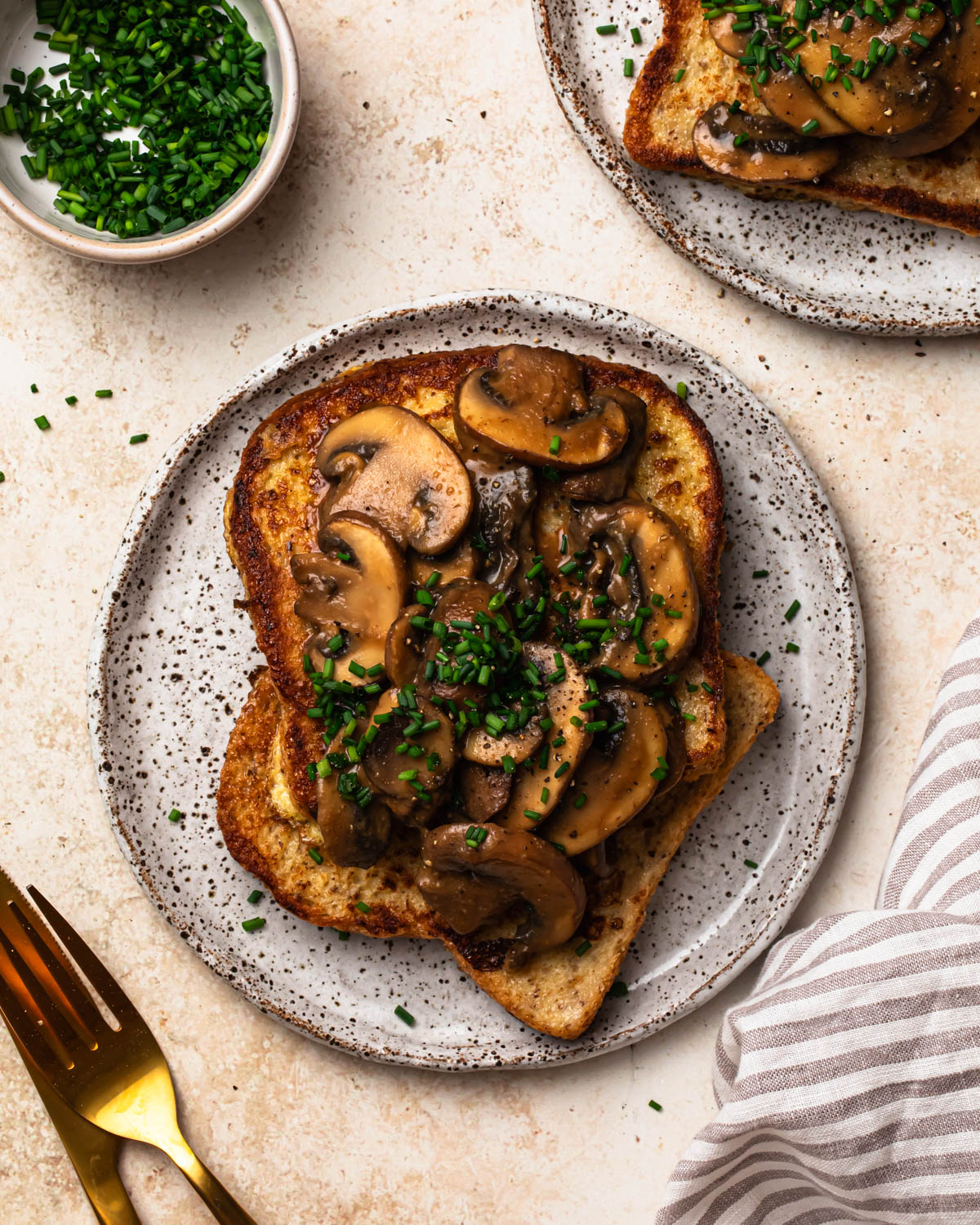 Top down image of Savoury French Toast on a plate topped with miso butter mushrooms and chopped chives.