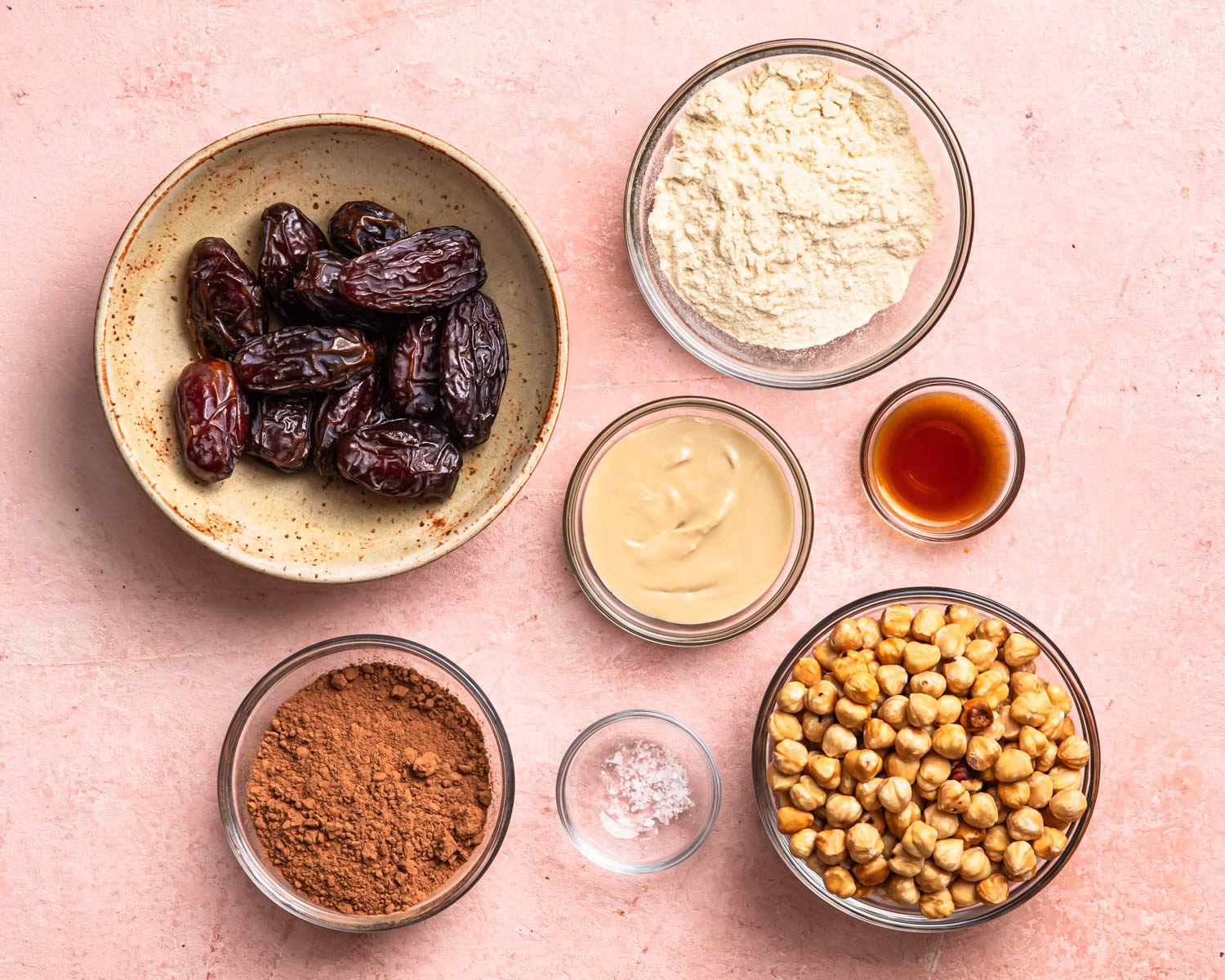 Ingredients for choc hazelnut no bake protein balls laid out in individual bowls.