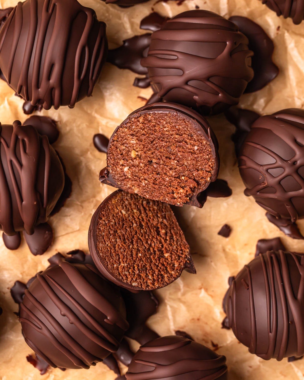 Close up photo of a double chocolate protein ball sliced in half, showing the cake like centre.