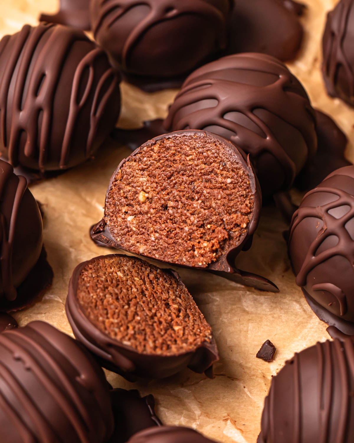 Close up photo of a double chocolate protein ball sliced in half, showing the cake like centre.