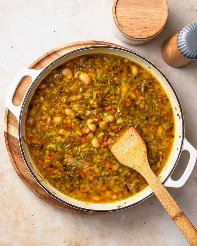 Brothy beans in a pan.
