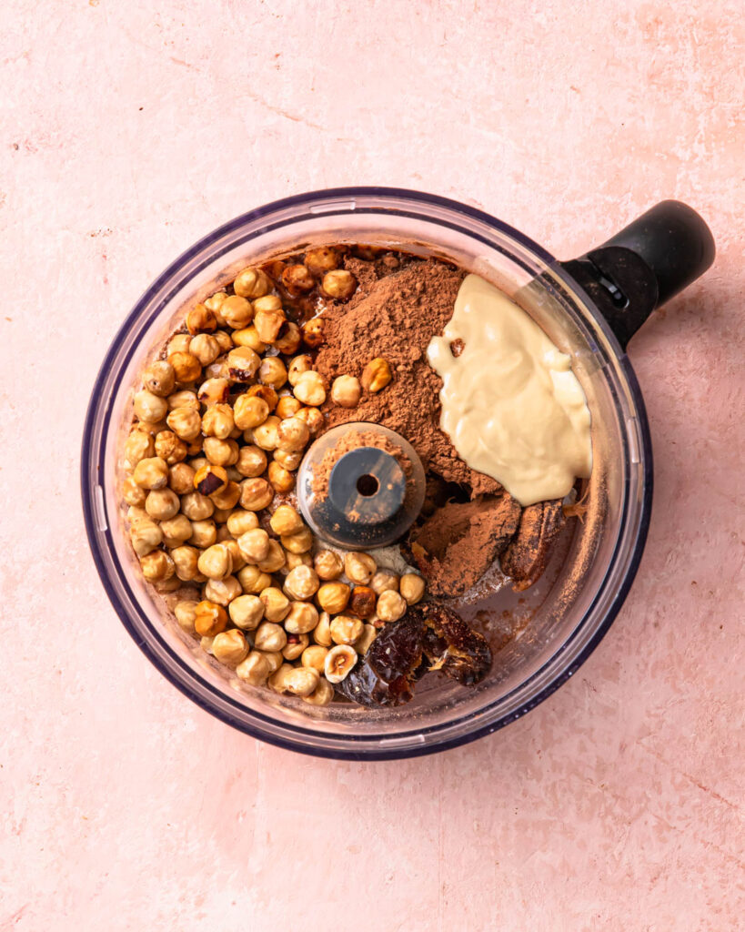Ingredients for no bake protein balls added to the drum of a food processor. 
