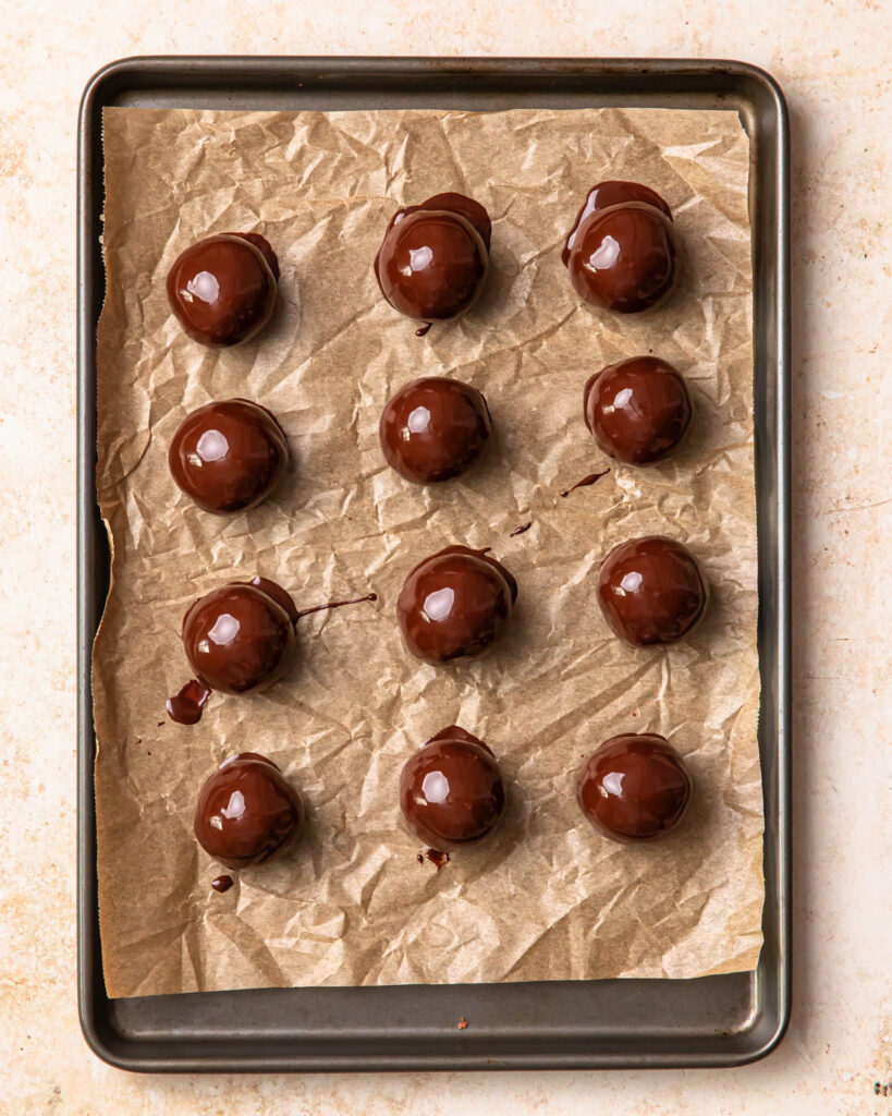 Double chocolate protein balls lined up on a baking tray, ready to go in the fridge to be set.