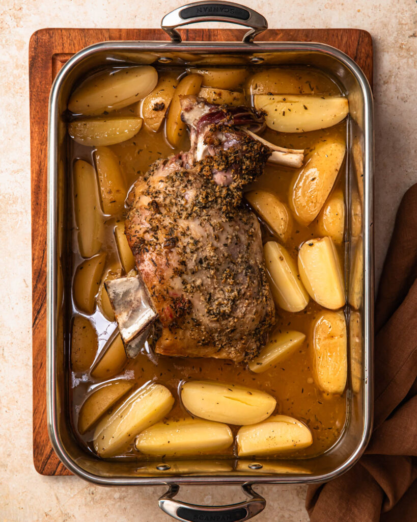 Slow cooked lamb shoulder in a roasting pan.