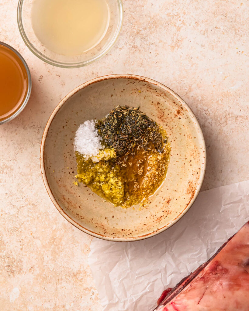 Ingredients for lemon herb rub in a small bowl. 