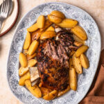 Slow cooked lamb shoulder resting on a bed of lemony potatoes.