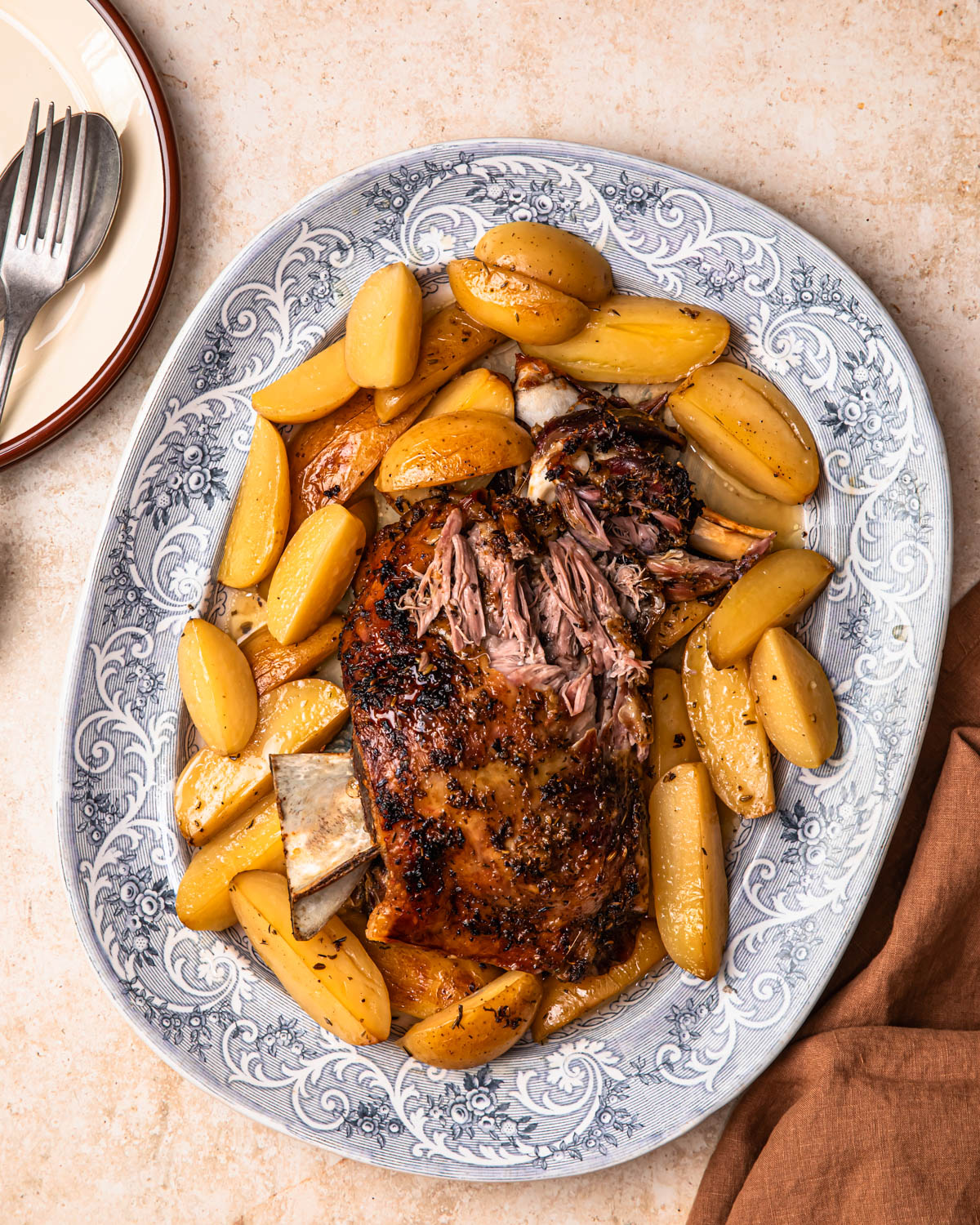Slow cooked lamb shoulder resting on a bed of lemony potatoes.