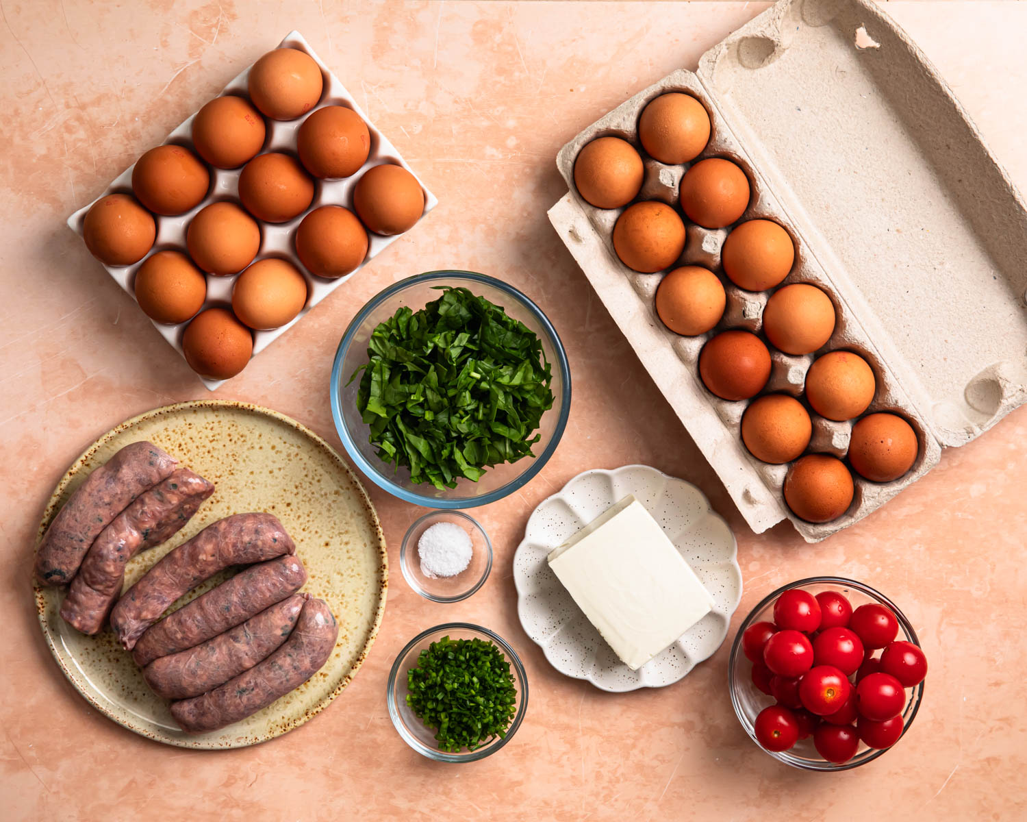 Ingredients for breakfast sausage egg cups laid out in individual bowls. 