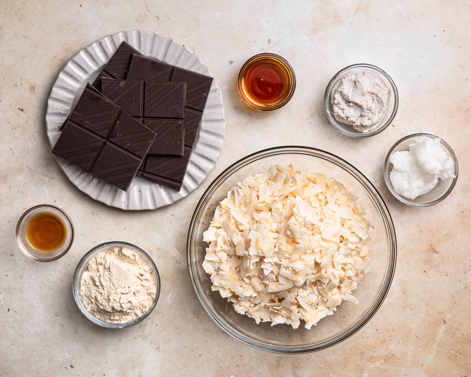 Ingredients for healthy homemade bounty bars laid out in individual bowls.