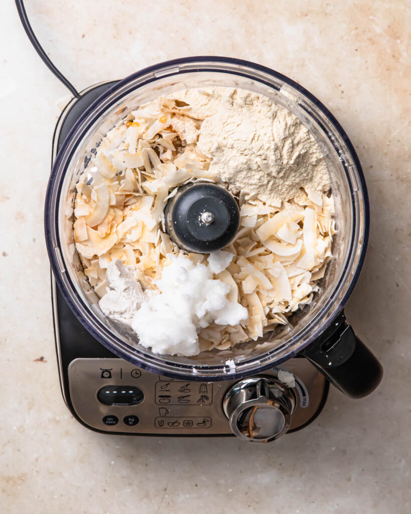 All of the ingredients for the bounty bars filling in the drum of a food processor.