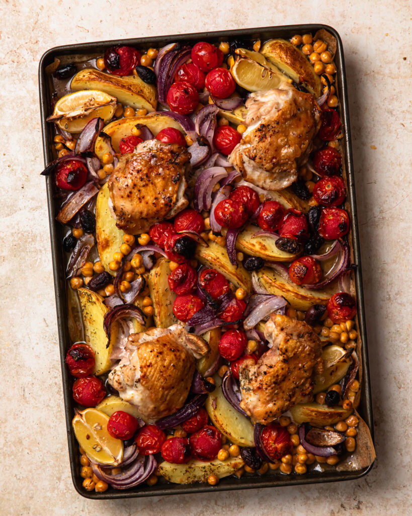 Mediterranean sheet pan chicken baked on a large pan.