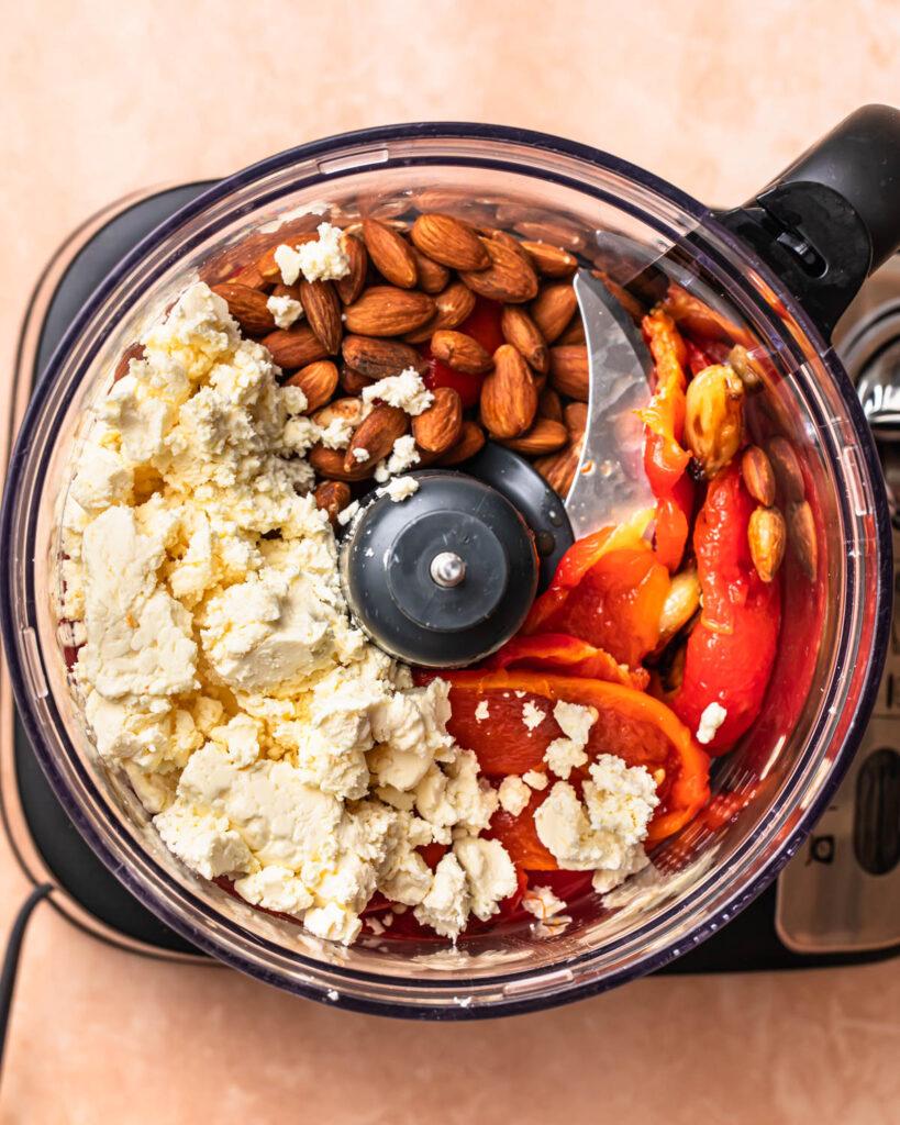 Ingredients for roasted red pepper and feta dip in a food processor. 