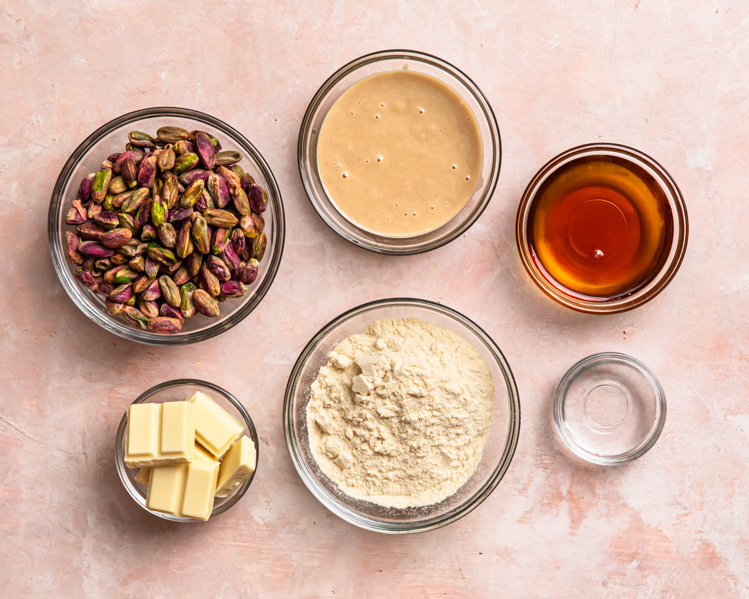 Ingredients to make pistachio protein balls laid out in individual bowls. 