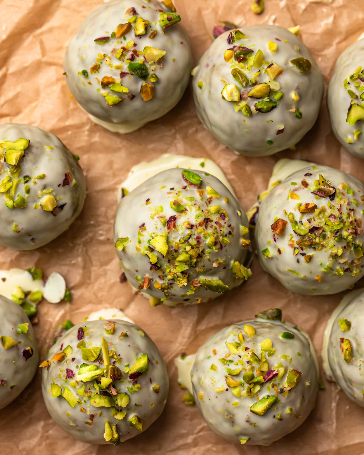Pistachio protein balls coated in white chocolate and topped with finely chopped pistachios. 