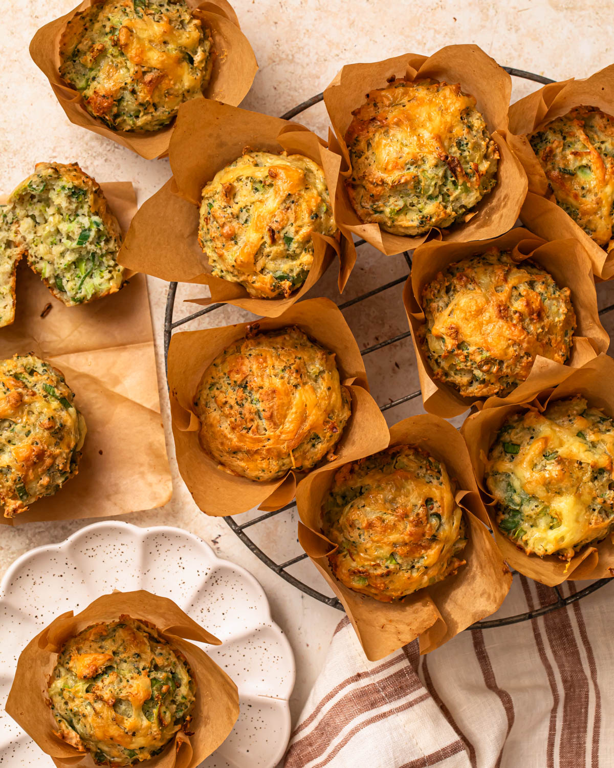 Gluten free savoury muffins, some cooling on a wire rack and some on plates.