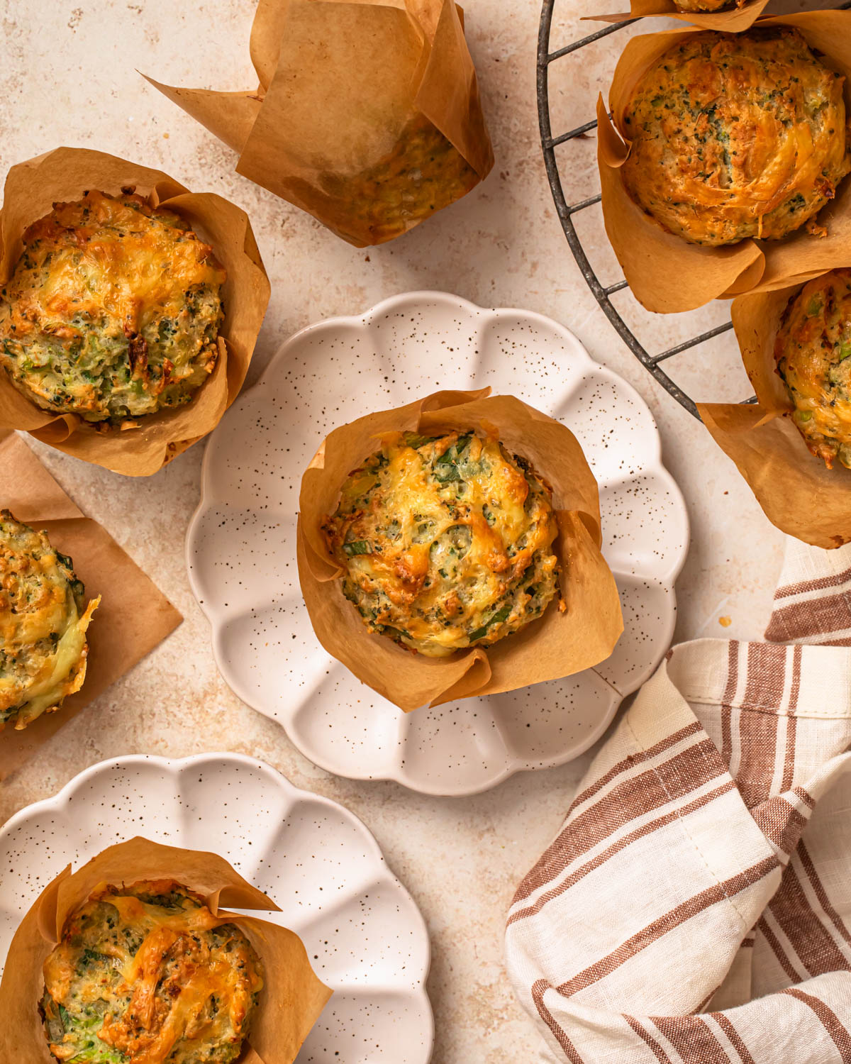 Gluten free savoury muffins, some cooling on a wire rack and some on plates. 