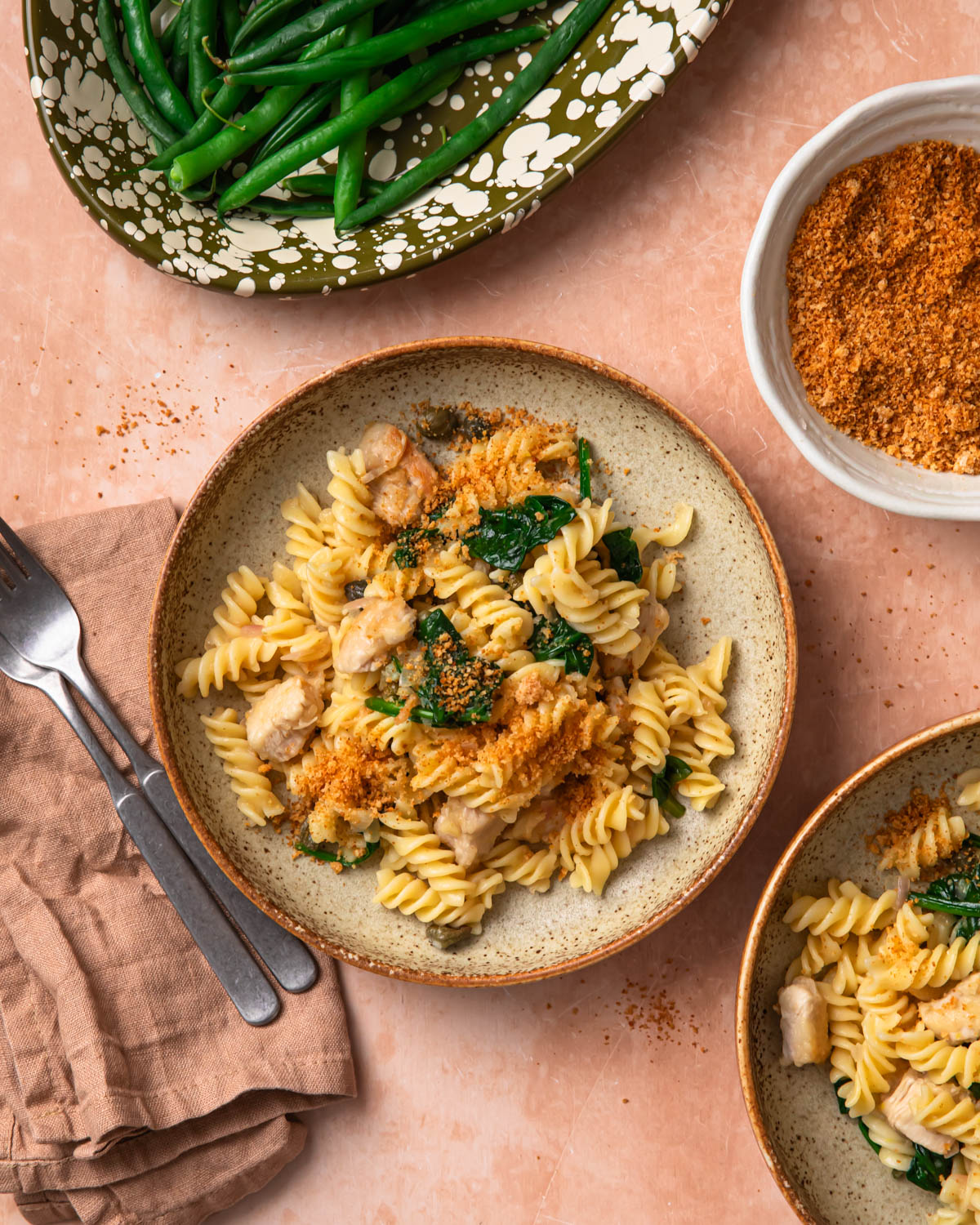 Chicken piccata pasta in a bowl topped with golden brown parmesan breadcrumbs.