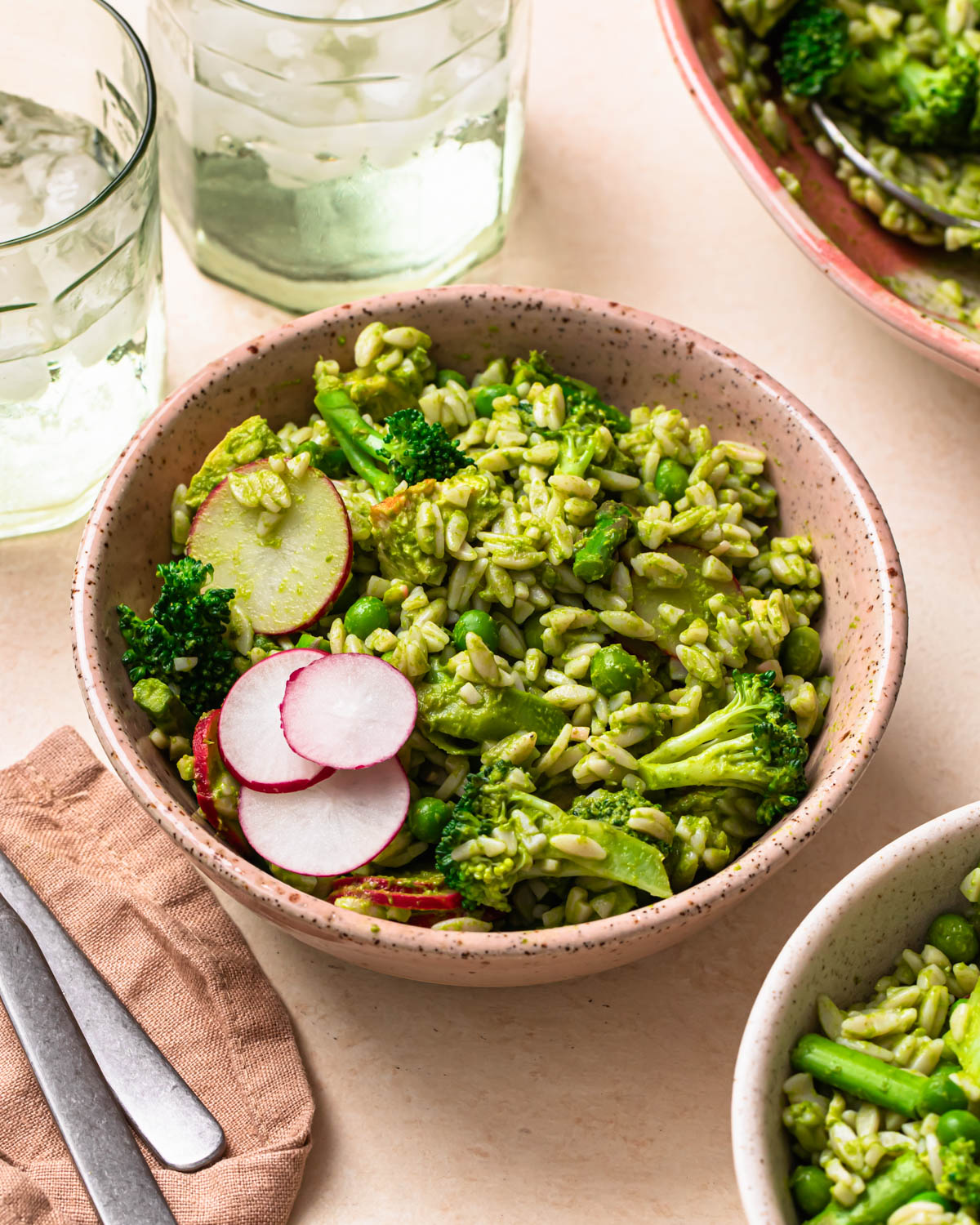 Eat Your Greens Chicken Orzo Salad in served in a bowl, topped with fresh radish.