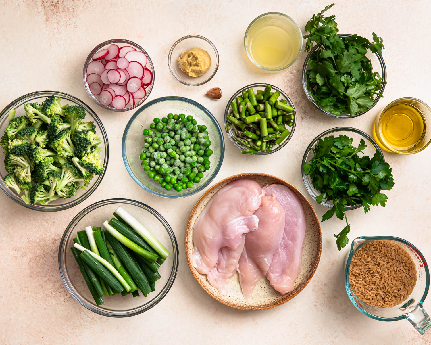 Ingredients for orzo salad laid out in individual bowls.