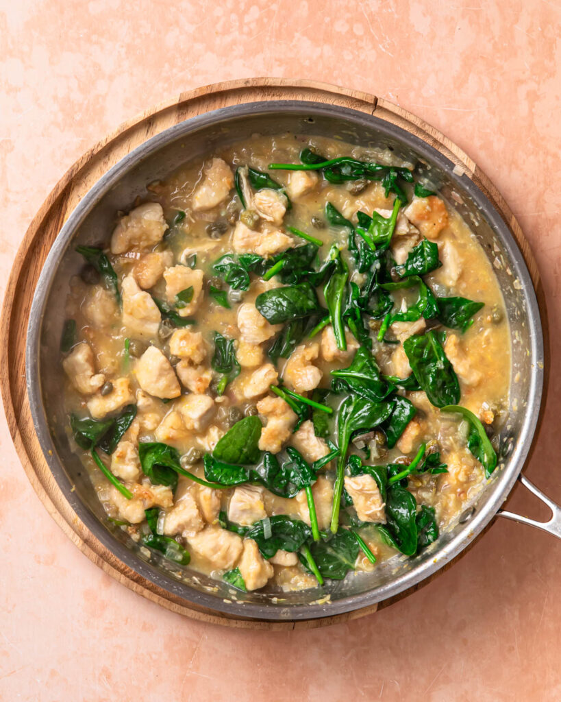 Baby spinach wilted into chicken piccata pasta sauce.
