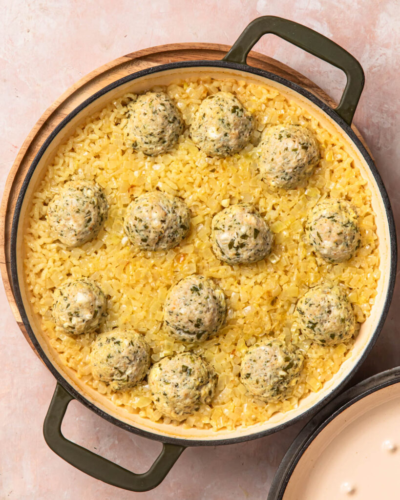 Cooked Greek chicken meatballs and rice in a pan.
