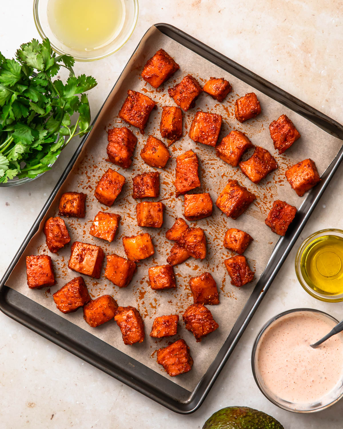 Seasoned salmon on a baking tray.