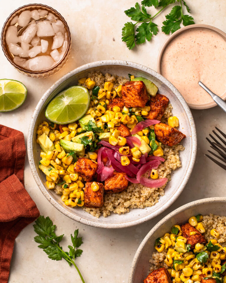 Tex mex salmon quinoa bowls topped with a wedge of lime.