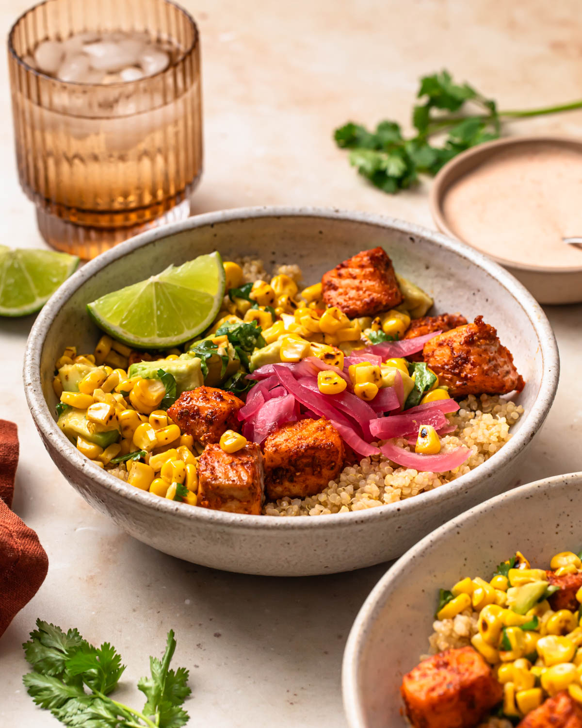 Tex mex salmon quinoa bowls topped with a wedge of lime.