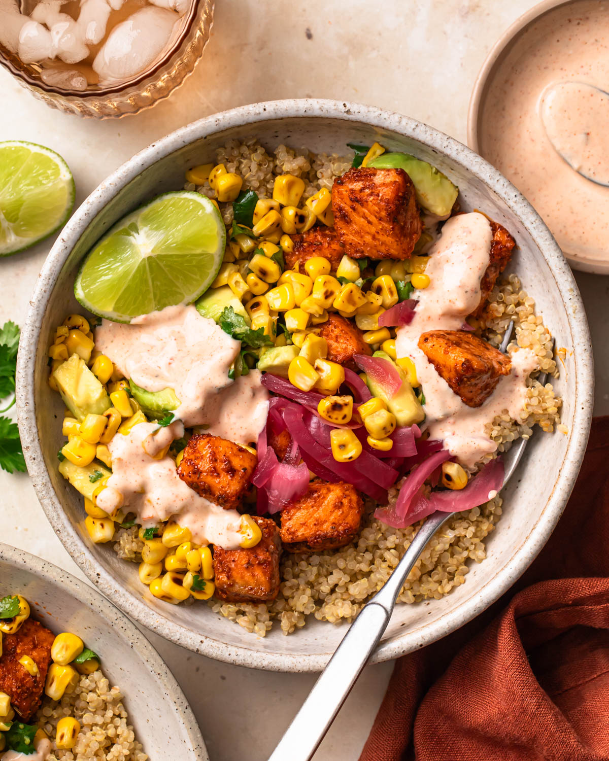 Close up of Tex mex salmon quinoa bowls topped with a wedge of lime and chipotle mayonnaise.