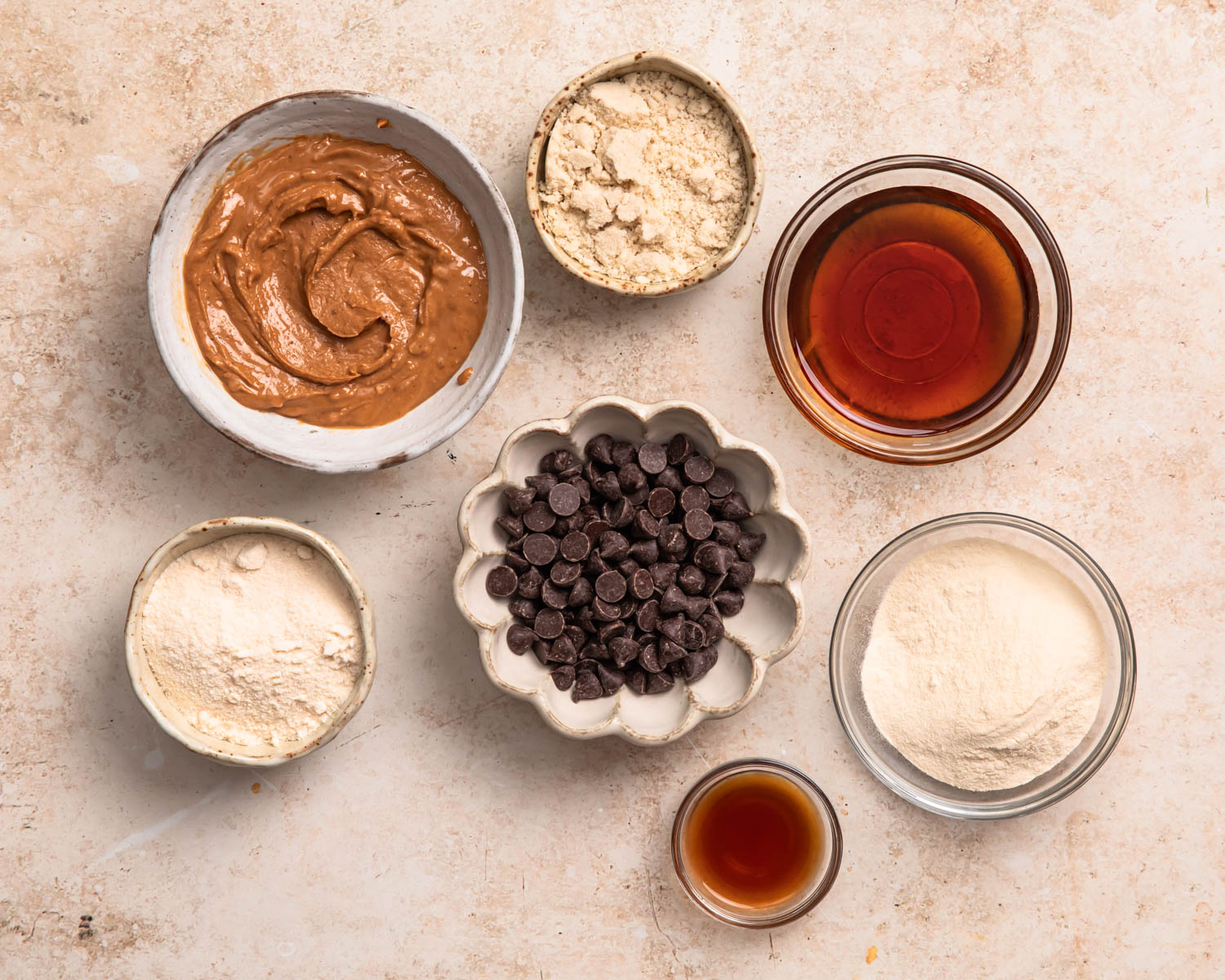 Ingredients for cookie dough protein balls laid out in individual bowls. 