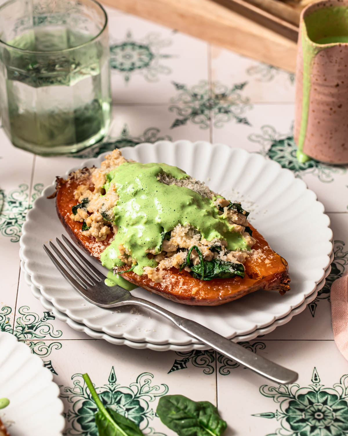 Front on photo of Lemony ground turkey stuffed sweet potato on a plate topped with a herby yoghurt sauce.