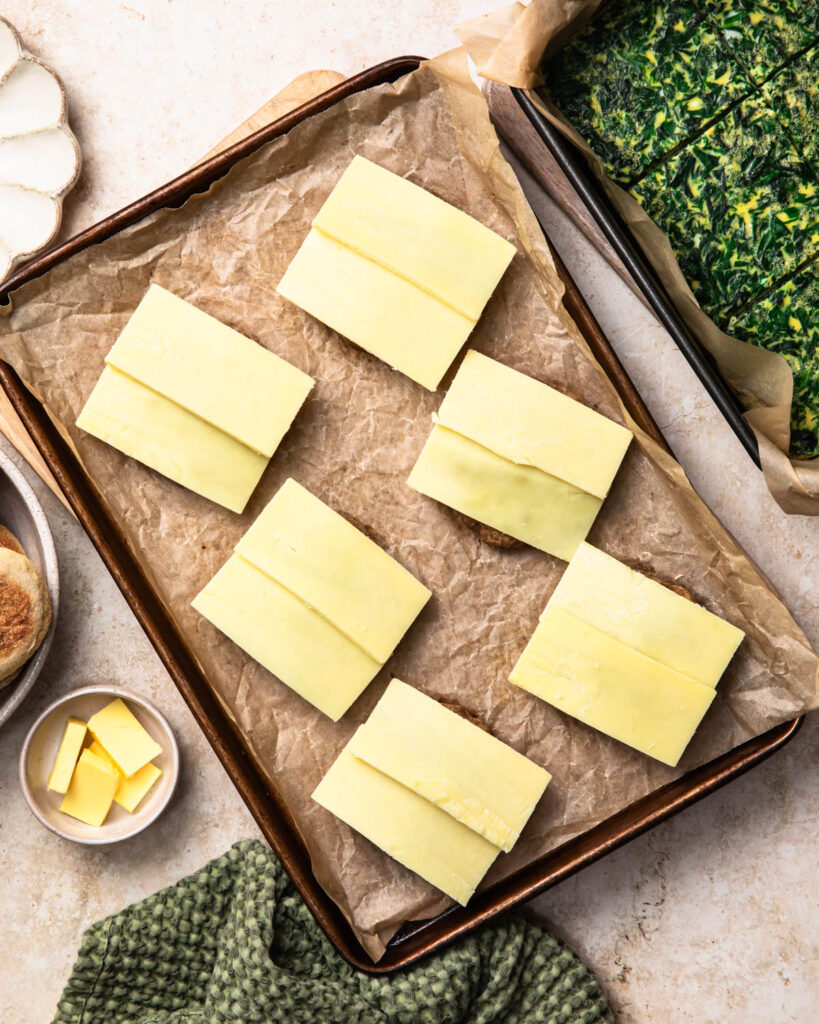 Cheese slices placed on top of baked sausage patties. 