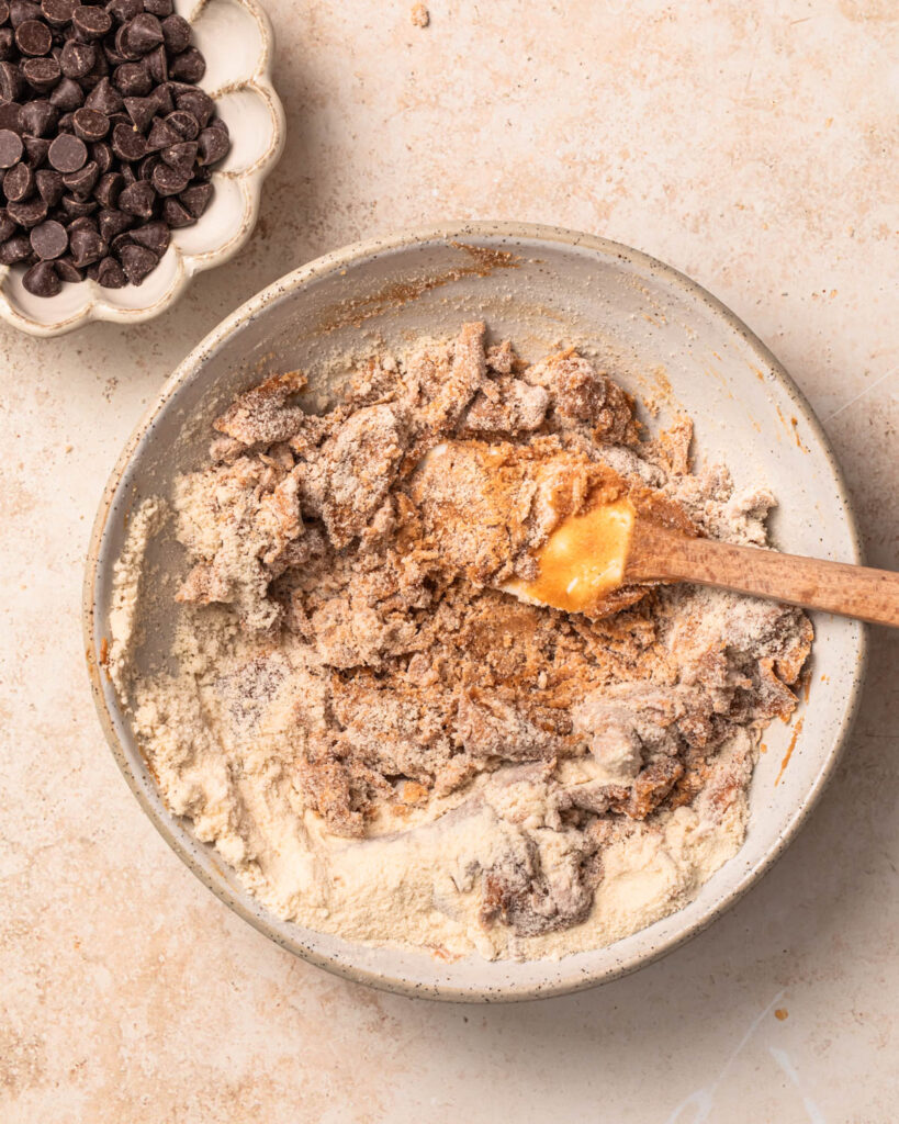 Dry ingredients being mixed into wet ingredients to make cookie dough protein balls.