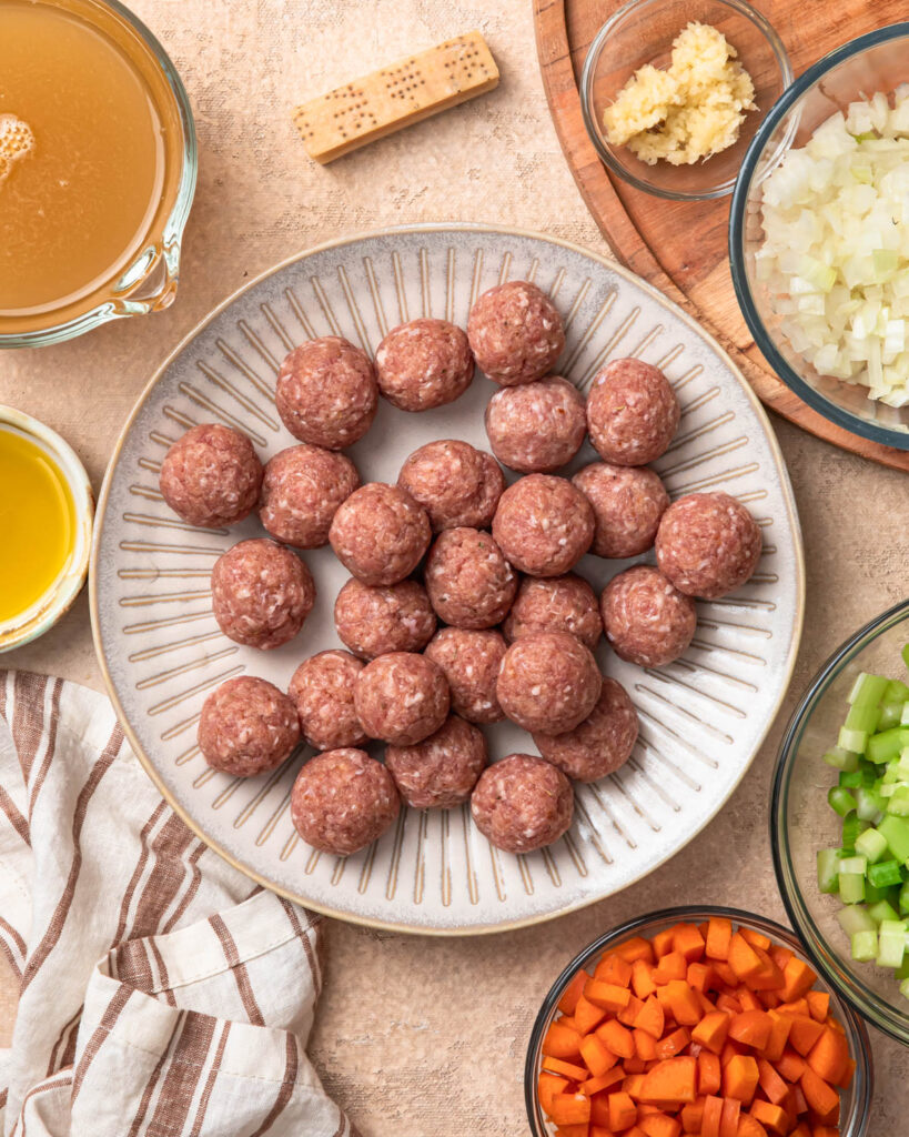 Pork meatballs on a plate, ready to be added to slow cooker meatball soup.